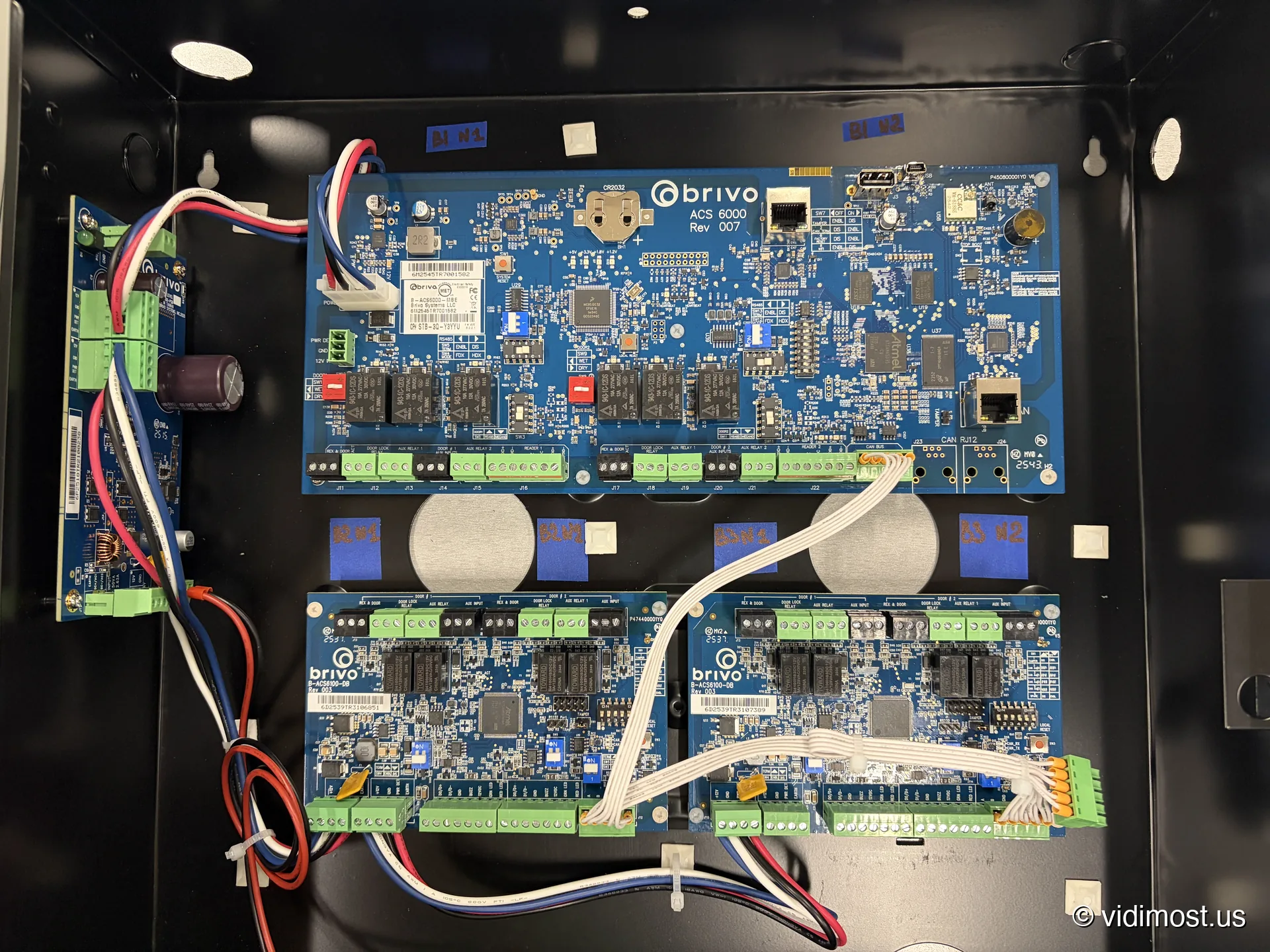 Brivo ACS 6000 controller with two ACS6100-DB two-door boards in a black cabinet, ports labeled with blue tape