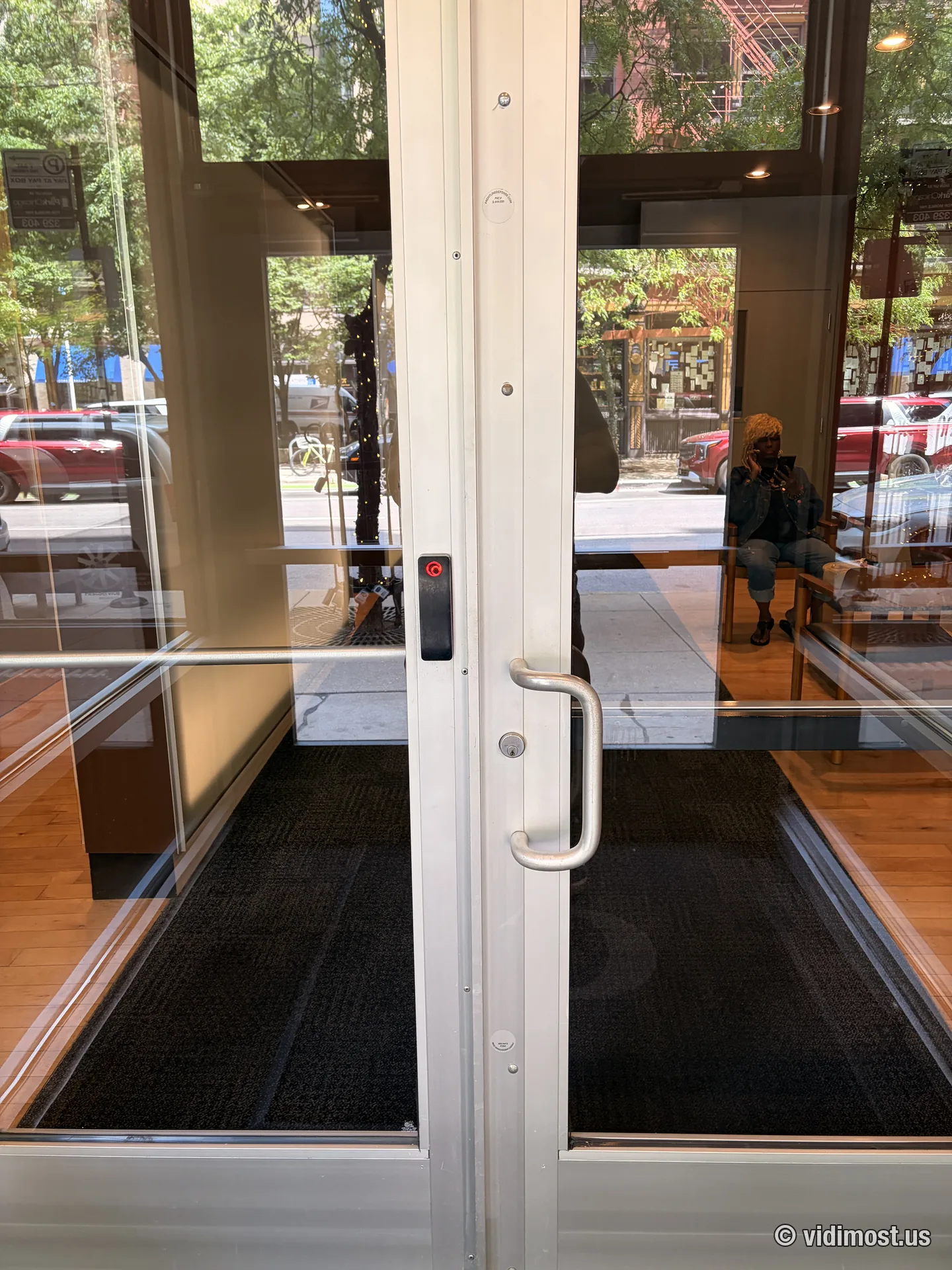 Black Brivo reader on the aluminum frame of a glass storefront double door in downtown Chicago