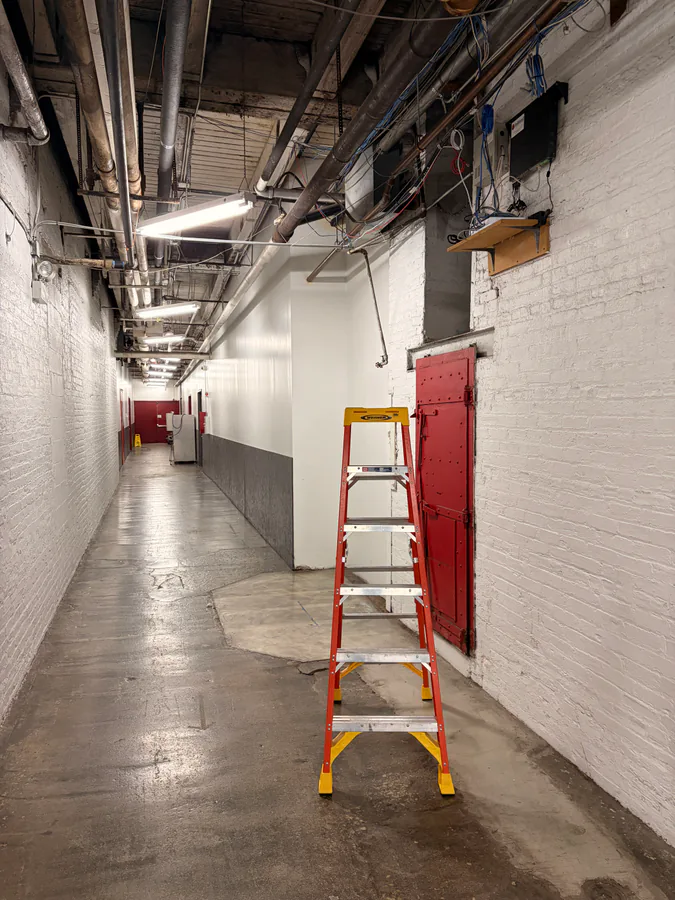 Vidimost technician walking through a Chicago commercial building during the discovery phase of a security system takeover, inspecting cameras and network equipment